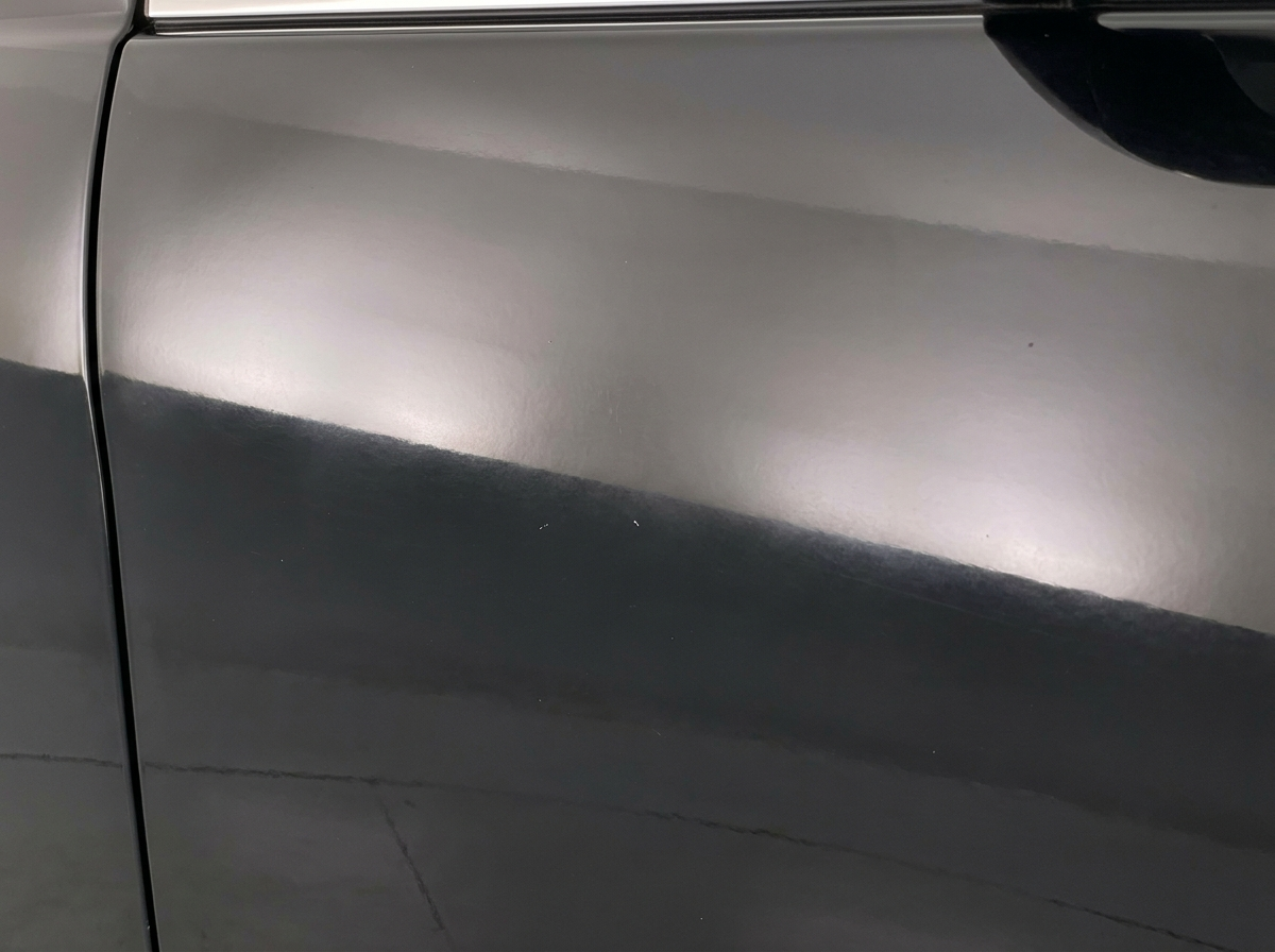 Close-up of glossy but slightly faded black car paint